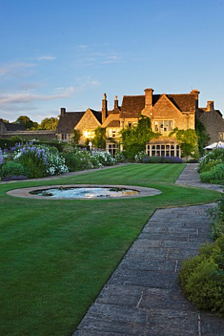 WHATLEY_MANOR__WILTSHIRE_VIEW_ACROSS_THE_MAIN_LAWN_TO_THE_MANOR_WITH_ROUND_POND