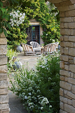 WHATLEY_MANOR__WILTSHIRE_VIEW_THROUGH_DOOR_TO_THE_BAR_TERRACE_WITH_TABLE_AND_CHAIRS