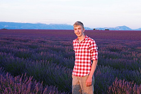 TEENAGE_BOY_AGED_16_WITH_RED_AND_WHITE_SHIRT_IN_FIELD_OF_PURPLE_LAVENDER_NEAR_VALENSOLE__PROVENCE__F