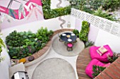 SMALL TOWN GARDEN  LONDON. DESIGNER - ANA SANCHEZ - MARTIN  OF GERMINATE DESIGN. VIEW LOOKING DOWN ONTO PINK AND WHITE GARDEN WITH DECKING  PINK CHAIRS  MOSAIC BY CELIA GREGORY