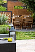 SMALL TOWN GARDEN  LONDON. DESIGNER - ANA SANCHEZ - MARTIN  OF GERMINATE DESIGN - SMALL TOWN GARDEN WITH WOODEN TABLE AND CHAIRS  SQUARE LANTERN  SCREENS MADE OF MILD STEEL