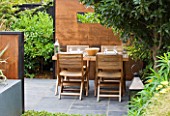SMALL TOWN GARDEN  LONDON. DESIGNER - ANA SANCHEZ - MARTIN  OF GERMINATE DESIGN - WOODEN TABLE AND CHAIRS  SQUARE LANTERN  SCREENS MADE OF MILD STEEL