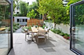 @JARDINROSAINSPIRATIONS - SMALL TOWN GARDEN: VIEW FROM KITCHEN TO WHITE PORCELAIN TILED DINING AREA/ PATIO.TABLE AND CHAIRS - A PLACE TO SIT