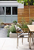 @JARDINROSAINSPIRATIONS - SMALL TOWN GARDEN: WHITE PORCELAIN TILED DINING AREA/ PATIO.TABLE AND CHAIRS - A PLACE TO SIT - BLUE SUMMERHOUSE AND RAISED BEDS IN BACKGROUND