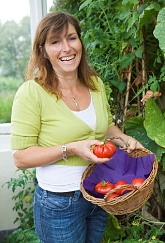 DESIGNER_CLARE_MATTHEWS_CLARE_HARVESTING_TOMATOES_IN_HER_CONSERVATORY