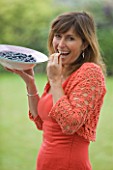DESIGNER CLARE MATTHEWS: CLARE HOLDING A BOWL OF BLUEBERRIES AND ABOUT TO EAT A BLUEBERRY