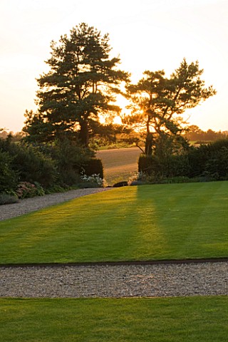 WHATLEY_MANOR__WILTSHIRE_VIEW_OUT_TO_THE_WILTSHIRE_COUNTRYSIDE_FROM_THE_GRAND_LAWN__EVENING_LIGHT