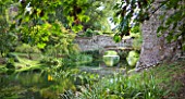 NINFA GARDEN, GIARDINI DI NINFA, ITALY: STREAM FLOWING THROUGH THE GARDENS WITH RUINED BUILDING AND BRIDGE. WALLS, WATER, STREAM, COUNTRY GARDEN, FLOW, FLOWING, MOVEMENT