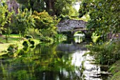 NINFA GARDEN, GIARDINI DI NINFA, ITALY: STREAM FLOWING THROUGH THE GARDENS WITH RUINED BUILDING AND BRIDGE. WALLS, WATER, STREAM, COUNTRY GARDEN, FLOW, FLOWING, MOVEMENT