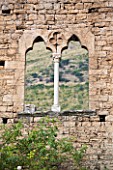 NINFA GARDEN, GIARDINI DI NINFA, ITALY: WINDOW THROUGH WALL RUIN. STONE, ANCIENT, RUINS, ITALIAN GARDEN, MEDITERRANEAN