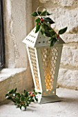 DESIGNER - JACKY HOBBS : CHRISTMAS DECORATION - CANDLES IN LANTERN WITH HOLLY BERRIES AND LEAVES  IN WINDOWSILL