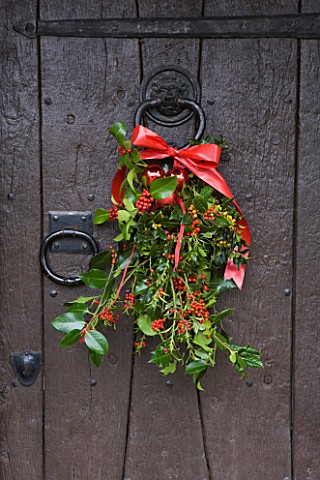 DESIGNER__JACKY_HOBBS__HOLLY_WREATH_ON_WOODEN_DOOR_WITH_RED_RIBBON