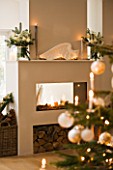 DESIGNER: JACKY HOBBS  LONDON: LIVING ROOM AT CHRISTMAS - CHRISTMAS TREE AND BAUBLES WITH FIREPLACE IN THE BACKGROUND