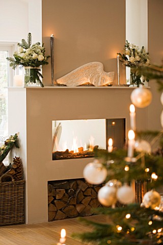 DESIGNER_JACKY_HOBBS__LONDON_LIVING_ROOM_AT_CHRISTMAS__CHRISTMAS_TREE_AND_BAUBLES_WITH_FIREPLACE_IN_