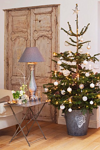 DESIGNER_JACKY_HOBBS__LONDON__CHRISTMAS__TABLE_WITH_GLASS_JARS__CANDLES_AND_LAMP__IN_LIVING_ROOM_CHR