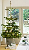 DESIGNER: JACKY HOBBS  LONDON: THE DINING ROOM AT CHRISTMAS WITH CHRISTMAS TREE AND PRESENTS