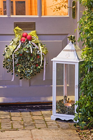 BRUERN_COTTAGES__OXFORDSHIRE_CHRISTMAS__DECORATIVE_HOLLY_WREATH_WITH_RED_BAUBLES_AND_RIBBON_ON_FRONT
