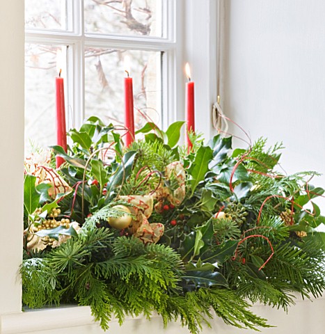 BRUERN_COTTAGES__OXFORDSHIRE_CHRISTMAS__WINDOWSILL_DECORATION_WITH_RED_CANDLES