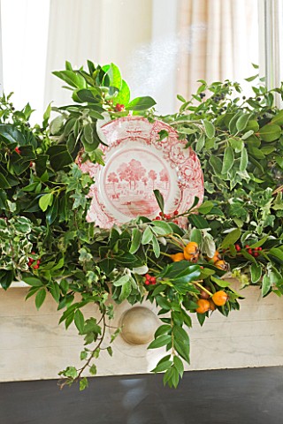 BRUERN_COTTAGES__OXFORDSHIRE_CHRISTMAS__FESTIVE_FOLIAGE_DECORATION_WITH_PLATE_ABOVE_FIREPLACES