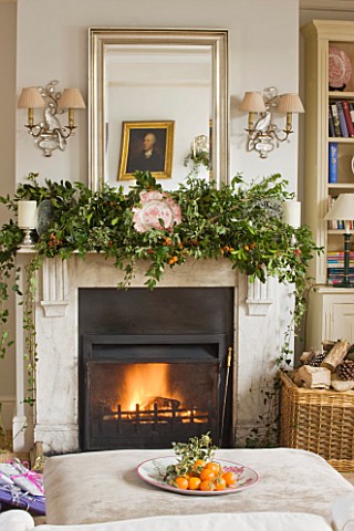 BRUERN_COTTAGES__OXFORDSHIRE_CHRISTMAS__THE_SITTING_ROOM_WITH_FIREPLACE_AND_OTTOMAN_WITH_BOWL_OF_SAT