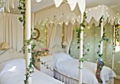 BRUERN COTTAGES  OXFORDSHIRE: CHRISTMAS - THE TWIN BEDROOM WITH CANOPIED TWIN BEDS. CREAM AND GREEN COLOUR SCHEME - CANOPIES BY JUDY PENFOLD INTERIORS