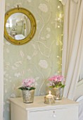 BRUERN COTTAGES  OXFORDSHIRE: CHRISTMAS - THE TWIN BEDROOM -  A TALL  NARROW PAINTED CHEST OF DRAWERS BETWEEN THE TWIN BEDS WITH CYCLAMEN IN CONTAINERS AND CONVEX MIRROR