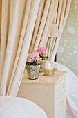 BRUERN COTTAGES  OXFORDSHIRE: CHRISTMAS - THE TWIN BEDROOM WITH CREAM AND GREEN COLOUR SCHEME - CHEST OF DRAWERS WITH CYCLAMEN IN CONTAINERS