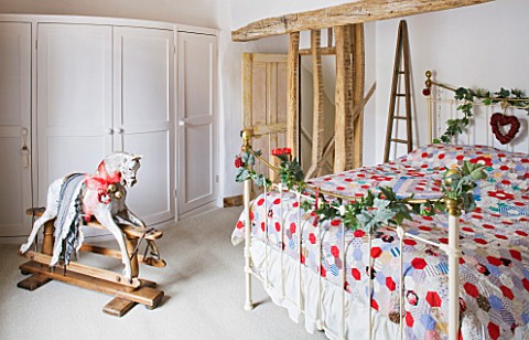 DESIGNER_CAROLYN_MINTY__GLOUCESTERSHIRE_BEDROOM_WITH_ROCKING_HORSE_AND_BED__HEART_AND_IVY__CHRISTMAS