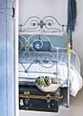 DESIGNER CAROLYN MINTY  GLOUCESTERSHIRE - GUEST BEDROOM WITH IRON BED AND VINTAGE LEATHER TRUNK