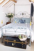 DESIGNER CAROLYN MINTY  GLOUCESTERSHIRE - GUEST BEDROOM WITH IRON BED AND VINTAGE LEATHER TRUNK