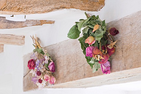 DESIGNER_CAROLYN_MINTY__GLOUCESTERSHIRE__THE_DINING_ROOM__DRIED_ROSES_ON_THE_BEAMS