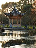 RHS GARDEN WISLEY  SURREY:  VIEW ACROSS THE LAKE AT SEVEN ACRES TO THE CHINESE PAGODA. WINTER  JANUARY.