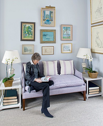 DESIGNER_JANE_CHURCHILL__THE_DRAWING_ROOM__JANE_SITS_ON_A_SOFA_WITH_SOME_OF_HER_FAVOURITE_PAINTINGS_