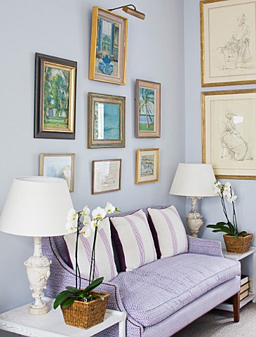 DESIGNER_JANE_CHURCHILL__THE_DRAWING_ROOM__FAVOURITE_PAINTINGS_HUNG_ABOVE_A_SOFA_IN_PRINTED_COTTON_B