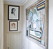 DESIGNER JANE CHURCHILL : ABSTRACT PAINTING WITH FAMILY PORTRAITS ON FIRST FLOOR LANDING