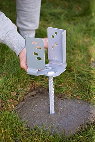 DESIGNER__CLARE_MATTHEWS_DECK_PROJECT__PUSHING_A_POST_HOLDER_INTO_CEMENT