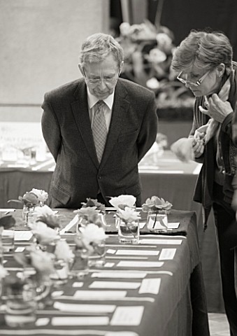 BLACK_AND_WHITE_IMAGE_OF_JUDGES_LOOKING_AT_CAMELLIAS_AT_THE_RHS_CAMELLIA_SHOW_IN_VINCENT_SQUARE__LON