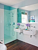 DESIGNER: KALLY ELLIS  LONDON: TWIN WASH BASINS IN BATHROOM WITH GLASS VASES OF LAVENDER SWEET PEAS. CLAUS PORTO SOAP. SHOWER