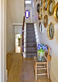 DESIGNER: KALLY ELLIS  LONDON: COLLECTION OF VINTAGE CONVEX MIRRORS IN ENTRANCE HALL  STAIRS