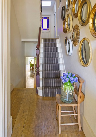 DESIGNER_KALLY_ELLIS__LONDON_COLLECTION_OF_VINTAGE_CONVEX_MIRRORS_IN_ENTRANCE_HALL__STAIRS