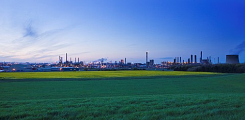 TEESSIDE__UNITED_KINGDOM__PETROCHEMICAL_WORKS_AT_DUSK_SEEN_FROM_FIELD_OF_RAPESEED__INDUSTRY__OIL_IND