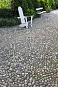 GARDEN OF PAOLO PEJRONE  ITALY: COBBLED PATH WITH WHITE WOODEN FURNITURE