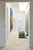 CAKE BOY HOUSE  LONDON: PAINTING ON THE WALL  IN THE HALLWAY BY ISABELLA KAY COMPRISED OF 50 MINI CANVASES AND STAIRCASE LEADING TO BASEMENT