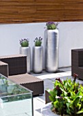 CAKE BOY HOUSE  LONDON: LAVENDER AND CALL LILIES IN PLANTERS FROM LONDON FLORISTS MCQUEENS. WEATHERPROOF FURNITURE  COURTYARD GARDEN
