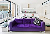 CAKE BOY HOUSE  LONDON: THE MORNING ROOM WITH INFORMAL DINING TABLE  PURPLE SUEDE SOFA BY ROSET AND KITCHEN BEHIND