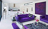 CAKE BOY HOUSE  LONDON: THE INFORMAL DINING ROOM WITH TABLE  PURPLE SUEDE SOFA AND KITCHEN