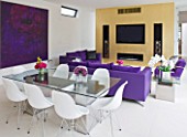CAKE BOY HOUSE  LONDON: THE INFORMAL DINING ROOM WITH TABLE  PURPLE SUEDE SOFA AND GOLD LEAF PAINTED MEDIA CENTRE ON THE BACK WALL IN THE MORNING ROOM