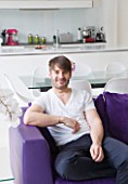 CAKE BOY HOUSE  LONDON: ERIC LANLARD  CAKE BOY  RELAXING IN HIS LIVING ROOM WITH KITCHEN IN BACKGROUND