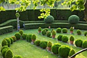 LES CONFINES  PROVENCE  FRANCE - DESIGNER: DOMINIQUE LAFOURCADE: FORMAL GARDEN OF CLIPPED EVERGREENS IN LAWN BESIDE ONE END OF THE HOUSE