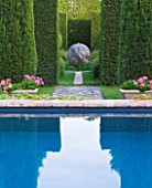 LES CONFINES  PROVENCE  FRANCE - DESIGNER: DOMINIQUE LAFOURCADE - SWIMMING POOL IN PORTUGUESE GARDEN AND VIEW THROUGH HEDGES TO BOULE GARDEN WITH LARGE ROUND STONE